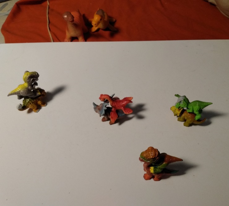 A BUNCH OF DINO FROZ ARE PLAYING THE RIDING GAME.