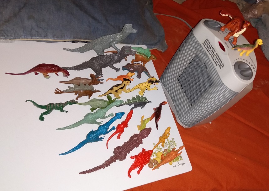 DINOSAURS GATHERING AROUND A HEATER.