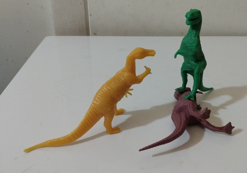 GREEN TYRANNOSAURUS STANDING ON TOP OF BROWN TYRANNOSAURUS