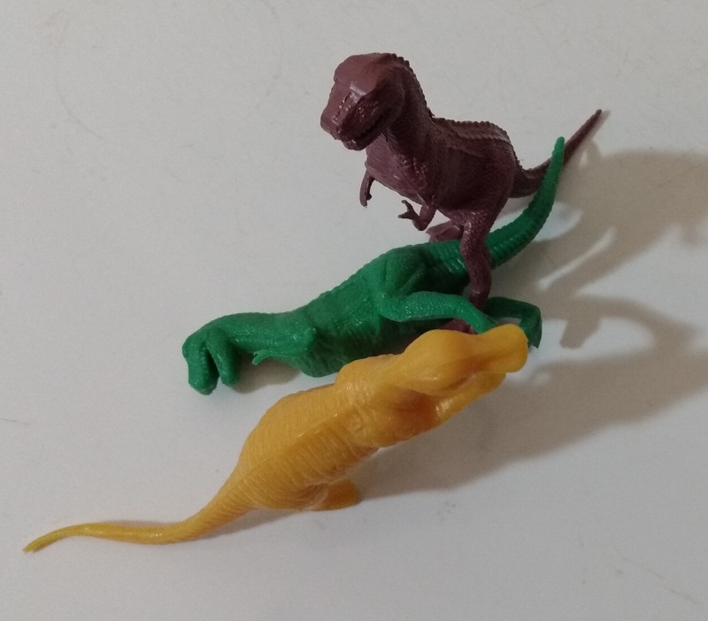 BROWN TYRANNOSAURUS STANDING ON TOP OF GREEN TYRANNOSAURUS